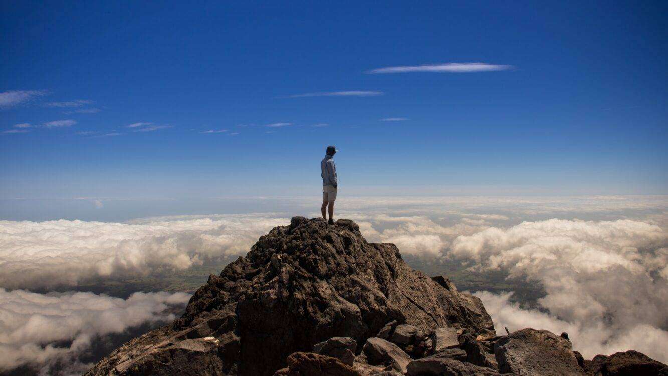 man standing on top of rock formation